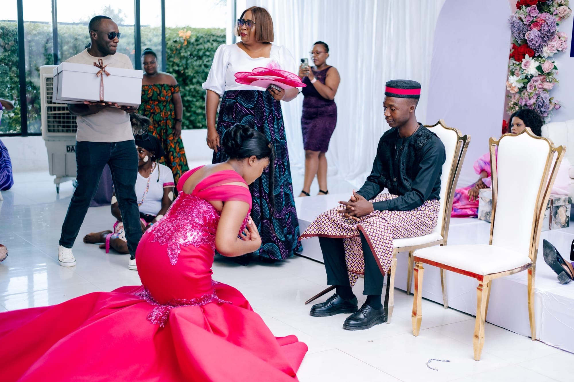 The bride kneeling before family elders during the traditional rite
